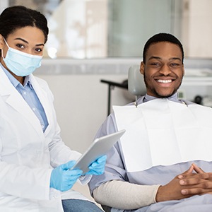 Smiling dentist and patient in treatment room