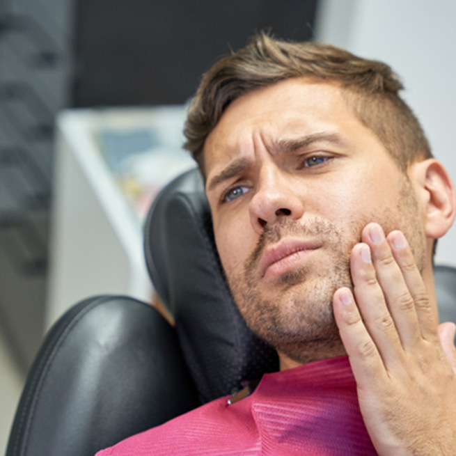 Patient with toothache sitting in treatment chair