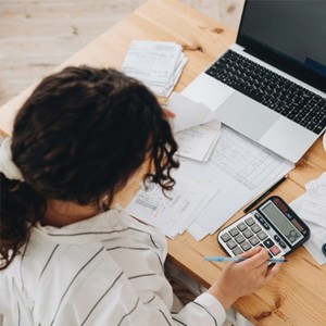 Woman at her desk with laptop and calculator