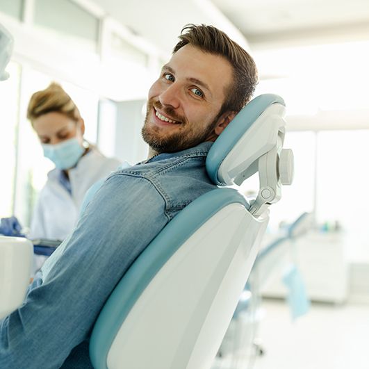 Man smiling while sitting in treatment chair