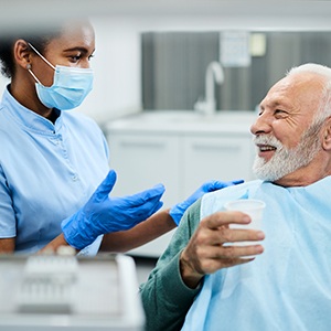 Smiling dentist and patient talking in treatment room