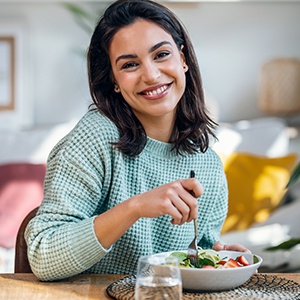 Woman smiling while eating meal at home