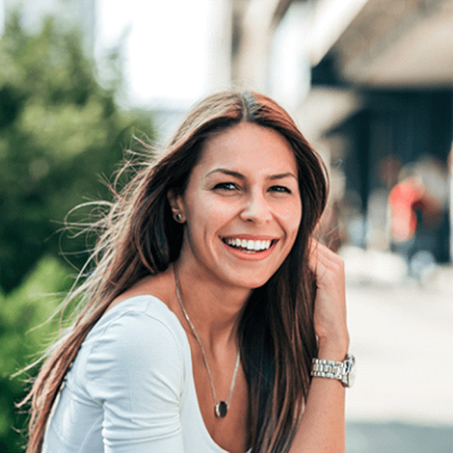 Woman with watch sitting outside and smiling