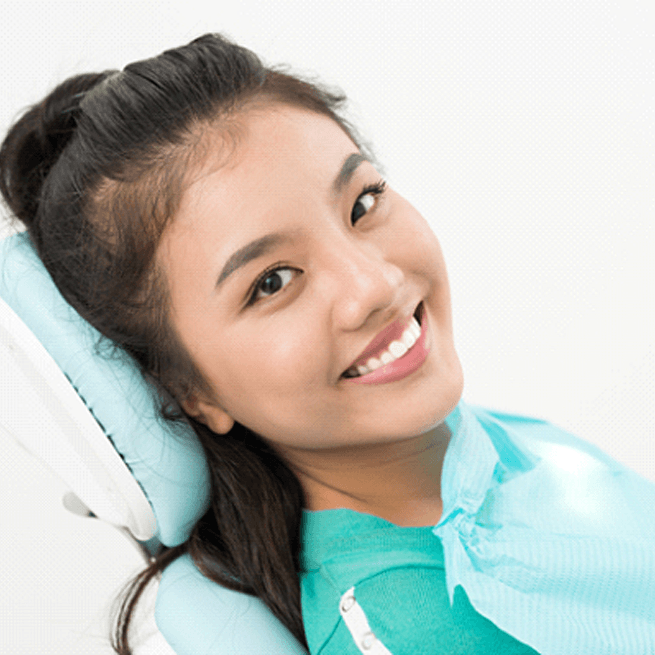 Woman leaning back in dental chair smiling