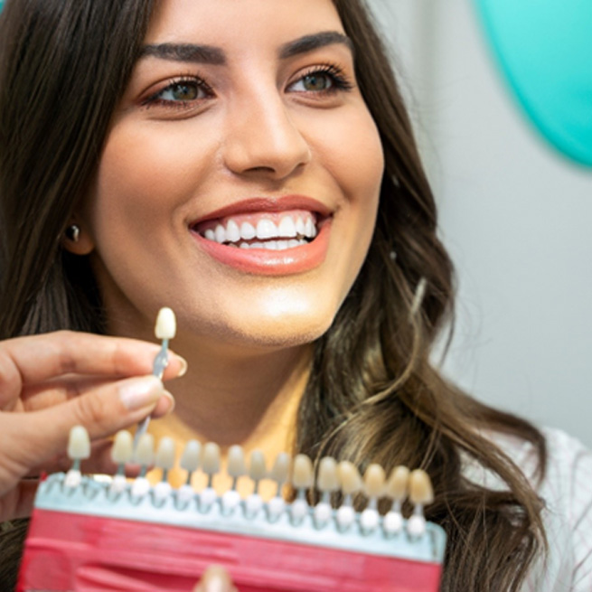 Woman admiring her smile after teeth whitening treatment