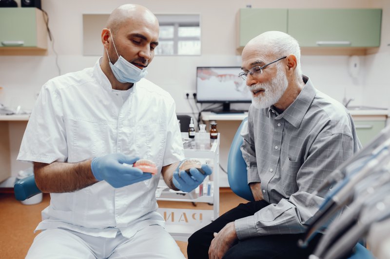 Older patient talking to dentist about dental implants