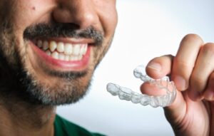 Man smiling while putting in his Invisalign