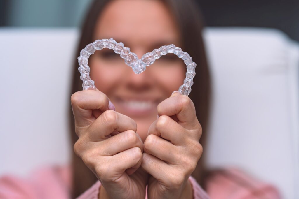 Woman holding Invisalign in the shape of a heart